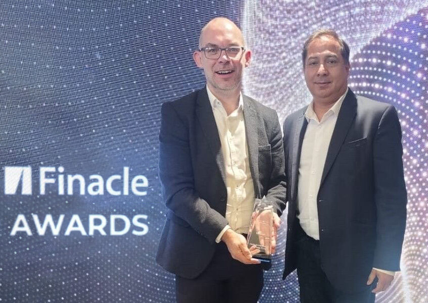 Bimal Gandhi and Paul Anderson holding up a Finacle award