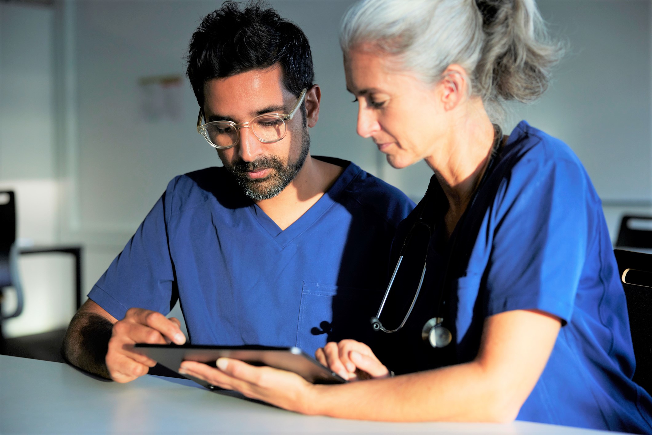 Two doctors working together looking at digital tablet